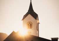 a church with a steeple and a clock at the top