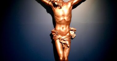 a statue of jesus on a cross in the dark