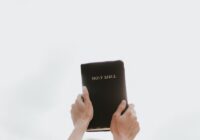 person holding Holy Bible