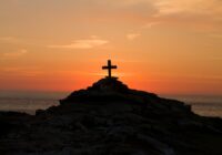 cross silhouette on mountain during golden hour