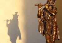 a bronze statue of a man playing a flute