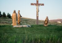 Crucifix statue on green grass