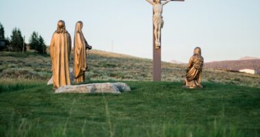 Crucifix statue on green grass