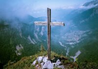 photo of brown wooden cross at cliff