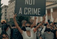 a group of people holding a sign that says color is not a crime