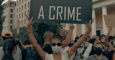 a group of people holding a sign that says color is not a crime
